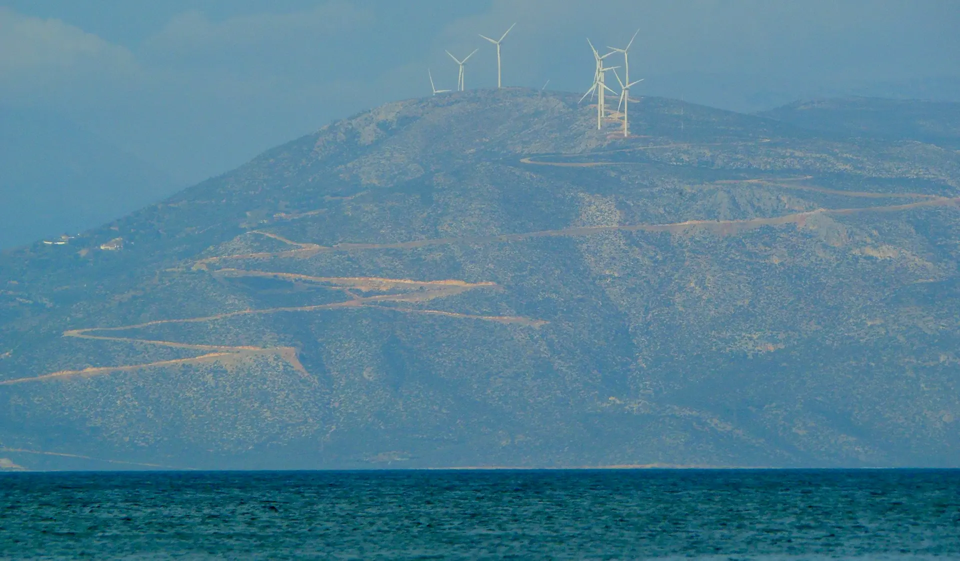 white sailboat on sea near mountain during daytime